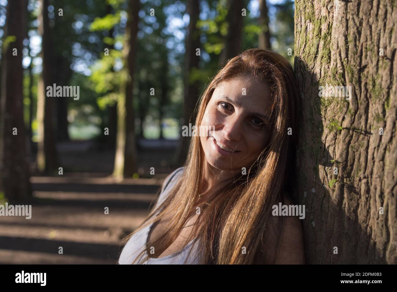 portrait d'une belle femme dans le parc, 40 ans, cheveux longs, souriant et heureux Banque D'Images