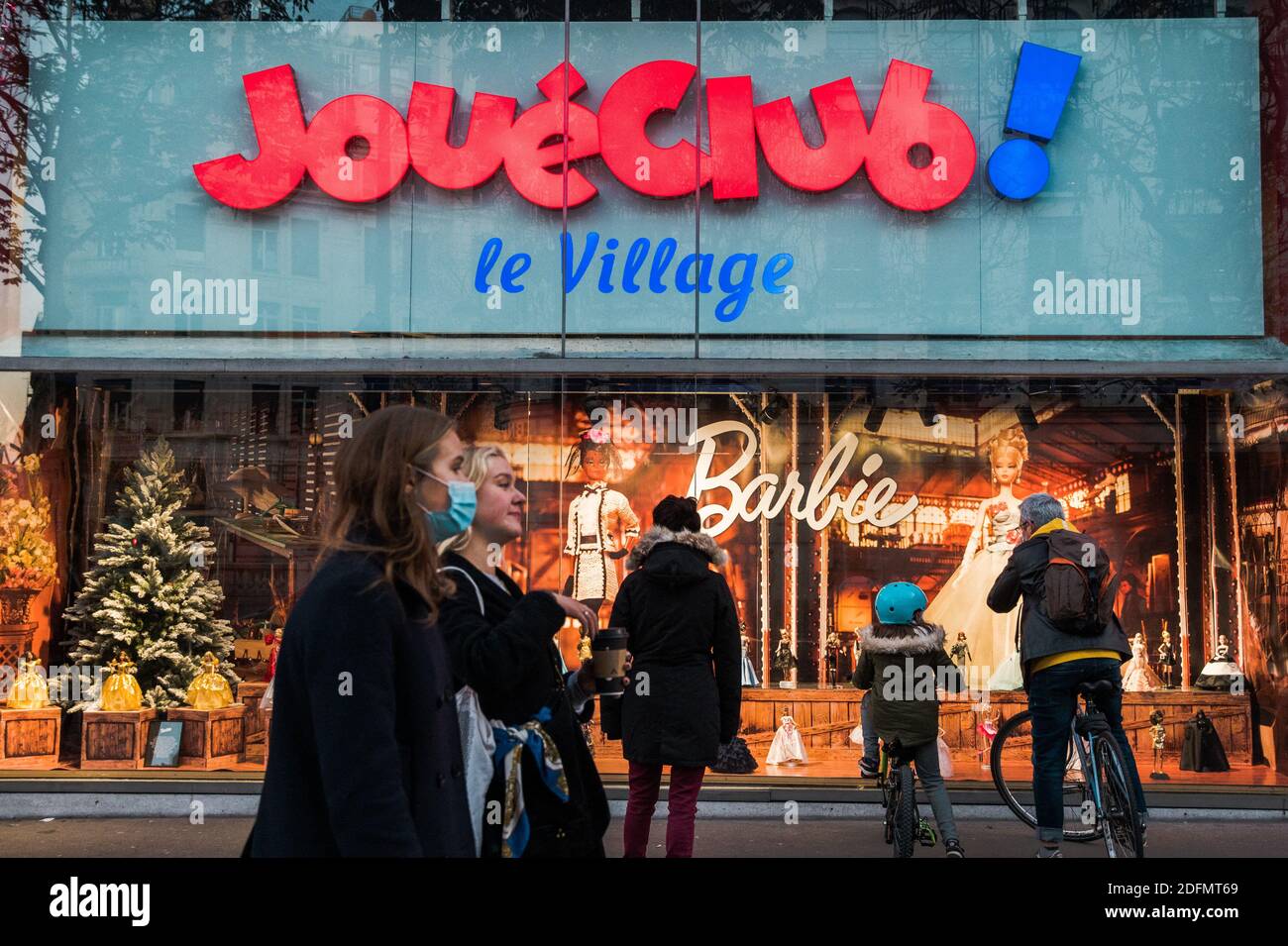 Les enfants et leurs familles regardent les vitrines d'un magasin de jouet,  le Joue Club, après que le gouvernement français ait assoupli les mesures  de confinement de Covid-19 et permis à toutes