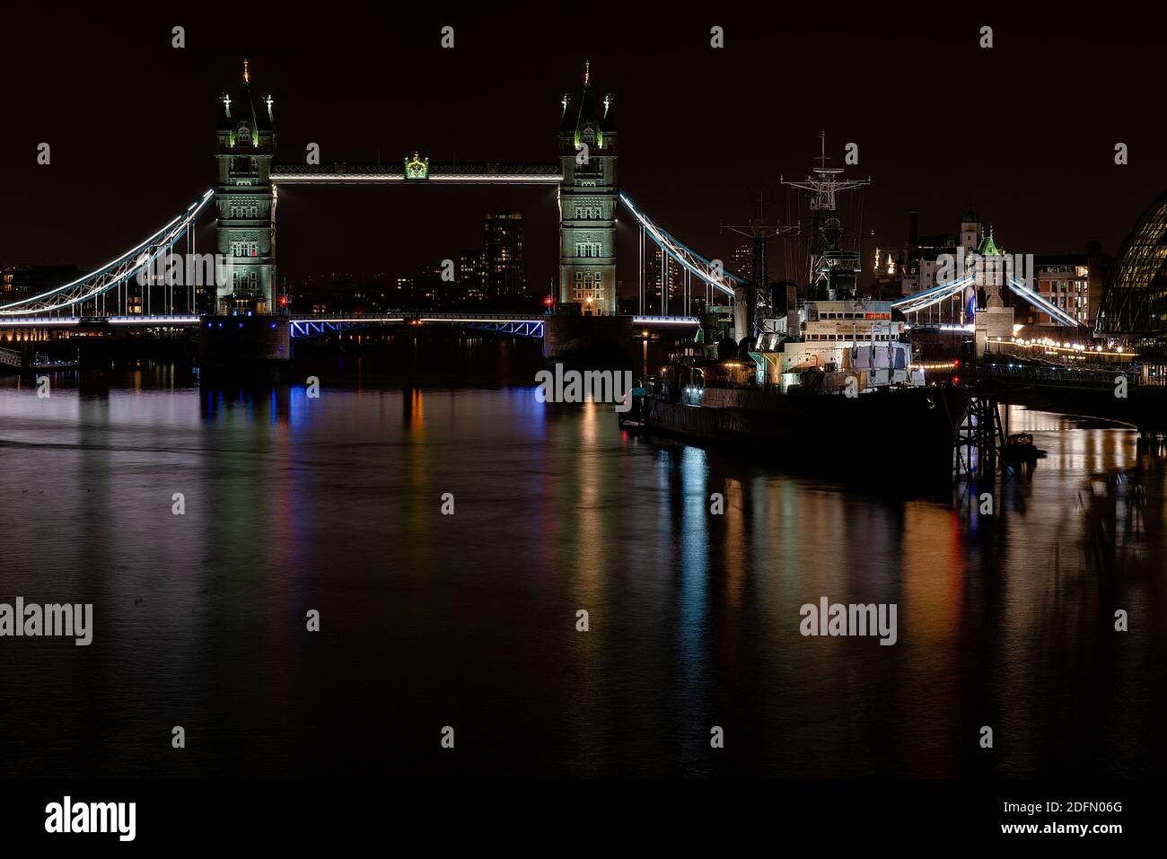 Londres, Royaume-Uni - 2020 janvier : paysage urbain nocturne avec HMS Belfast flottant sur la Tamise à côté de Tower Bridge. Exposition longue. Banque D'Images