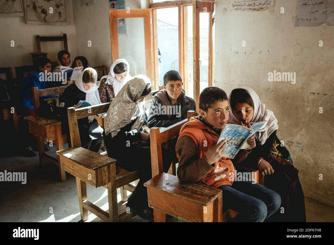 Neuf élèves dans les salles de classe, un garçon et une fille lisant dans la première banque, Potokh Primary School, Potokh, Wakhan Corridor, Afghanistan Banque D'Images