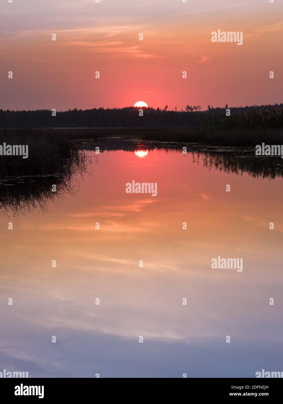 Paysage pittoresque au coucher du soleil avec reflets d'eau et couleurs d'ambiance à la soirée d'automne en Finlande. Banque D'Images