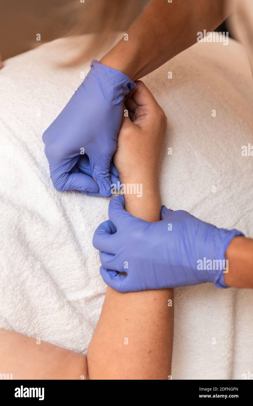 kinésithérapeute donnant le traitement avec l'acupuncture à aiguille sèche au patient dedans les mains Banque D'Images