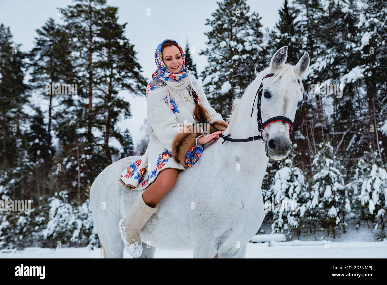 Jolie femme dans les vêtements traditionnels est de son cheval (concentrez-vous sur le visage du cheval) Banque D'Images