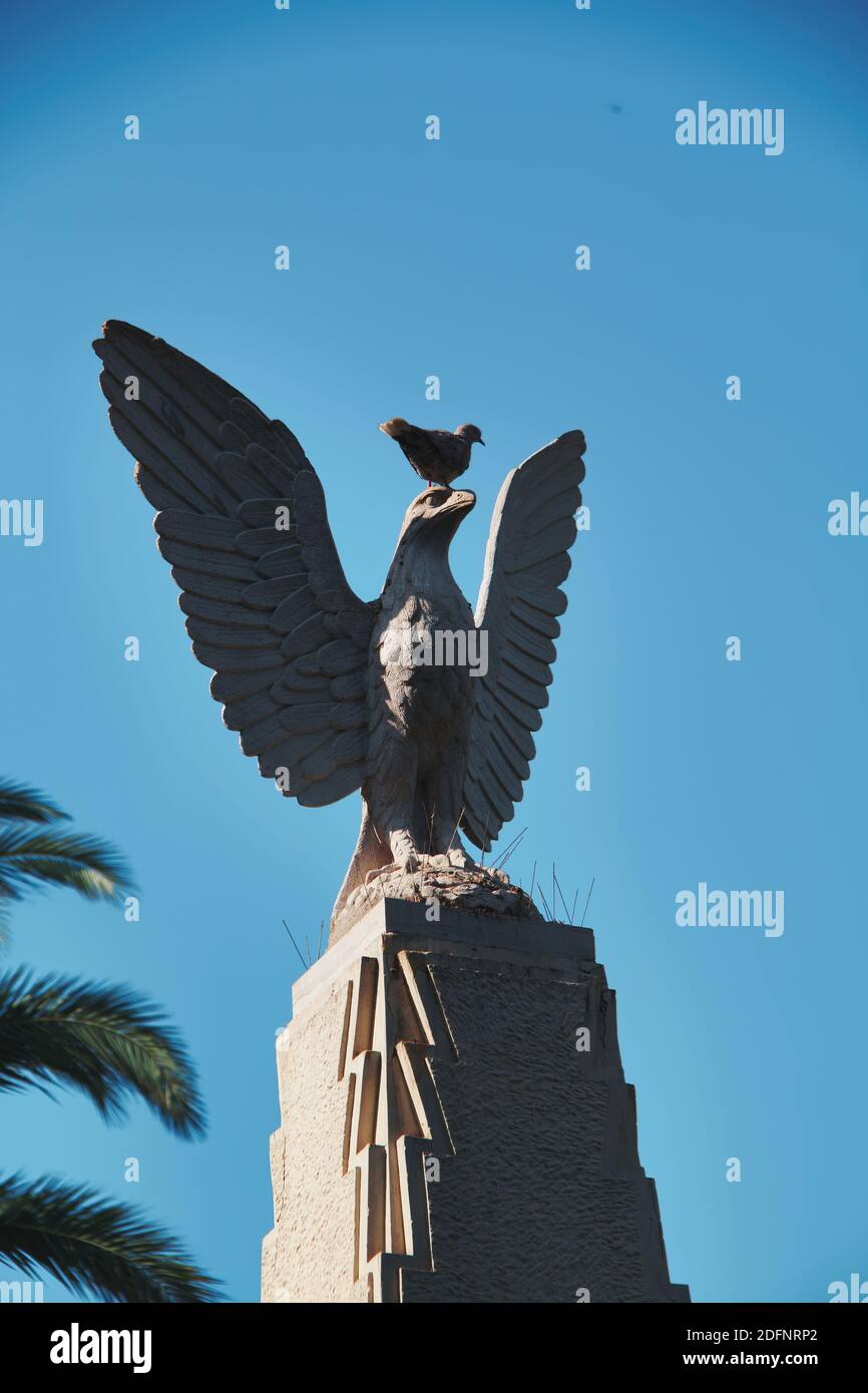 Statue d'un aigle en pierre entouré de pointes avec une colombe sur sa tête. Banque D'Images
