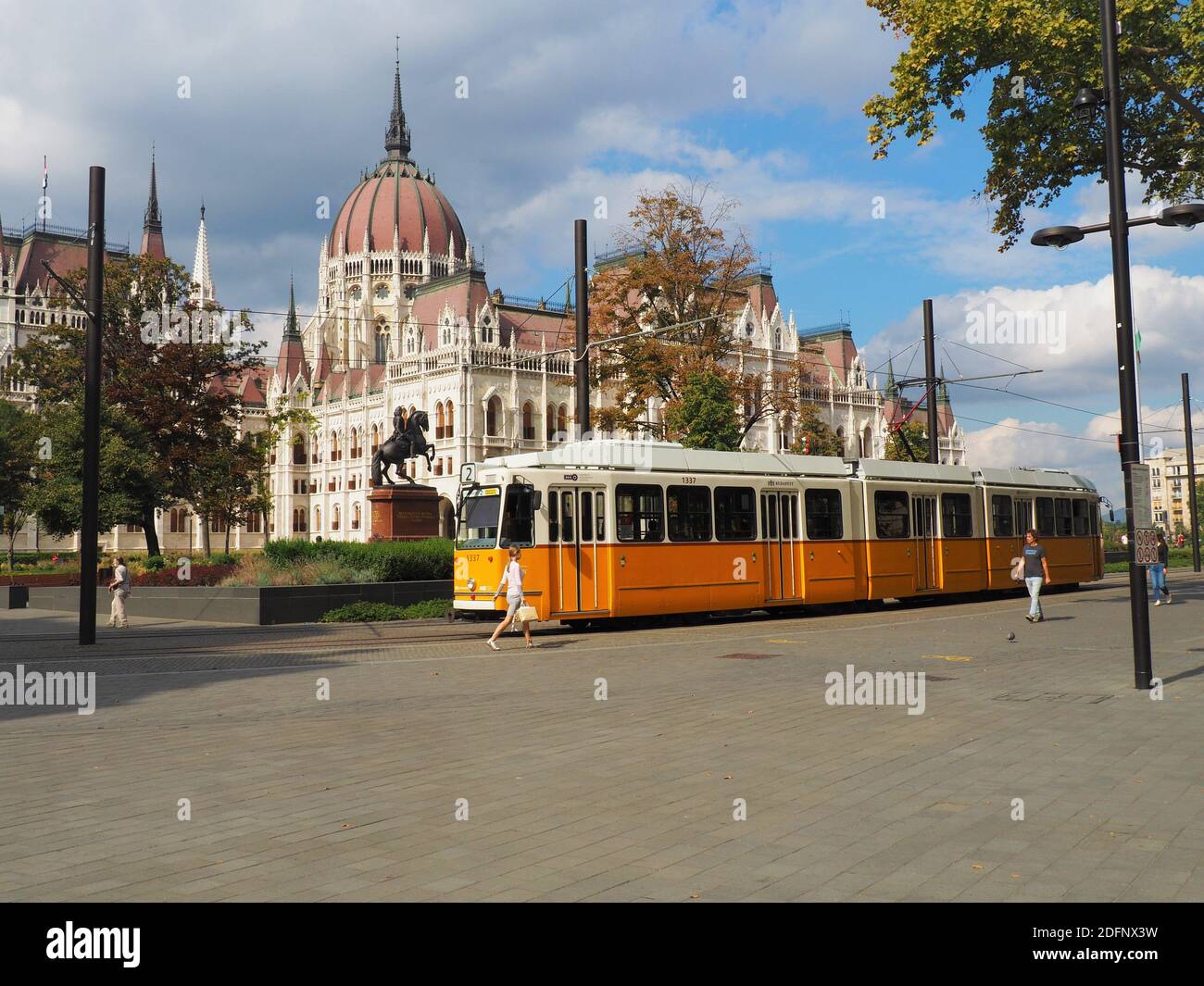 Budapest, Hongrie - 24 septembre 2020 : quelques personnes marchent sur la magnifique place Kossuth en face du tramway jaune et du Parlement hongrois blanc Banque D'Images