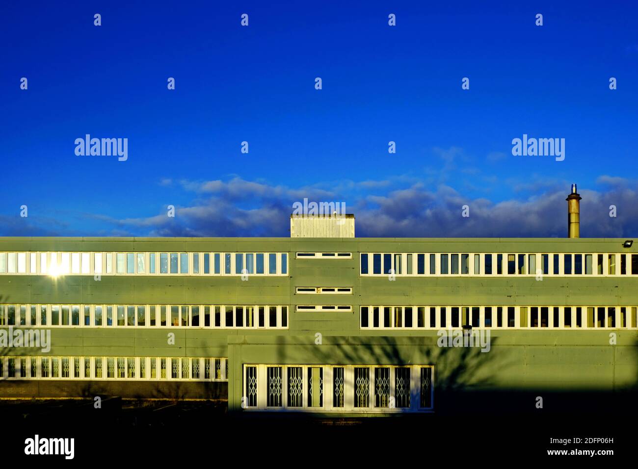 Ancien immeuble de bureaux abandonné en attente de démolition contre bleu profond ciel Banque D'Images