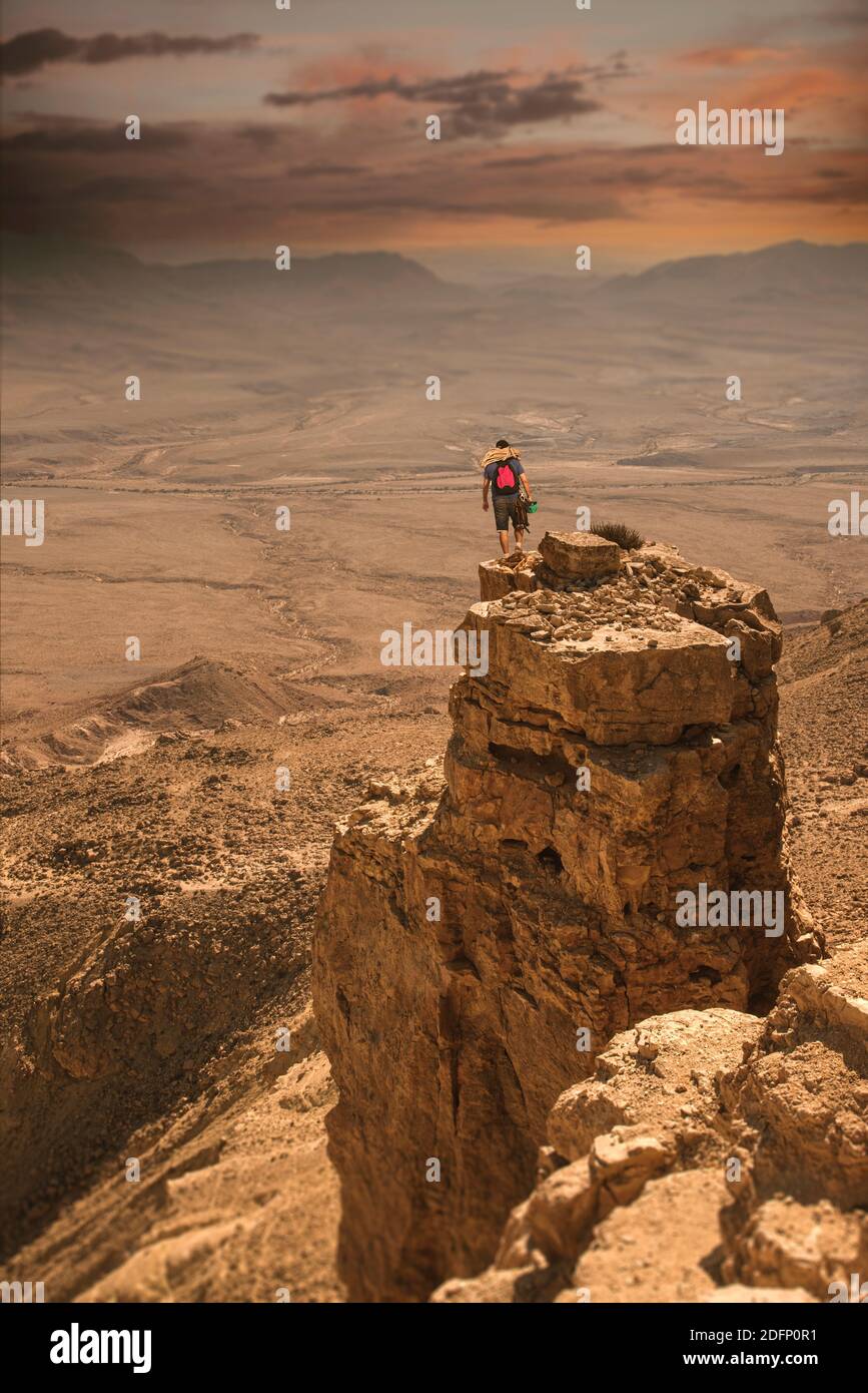 Le grimpeur de montagne BA se dresse sur une falaise, avec une corde et un casque, avant de descendre. Belle vue spectaculaire sur le désert. Nature sauvage. Paysage de la nature. Cratère de Makhtesh, cratère de Ramon, Israël. Photo de haute qualité Banque D'Images