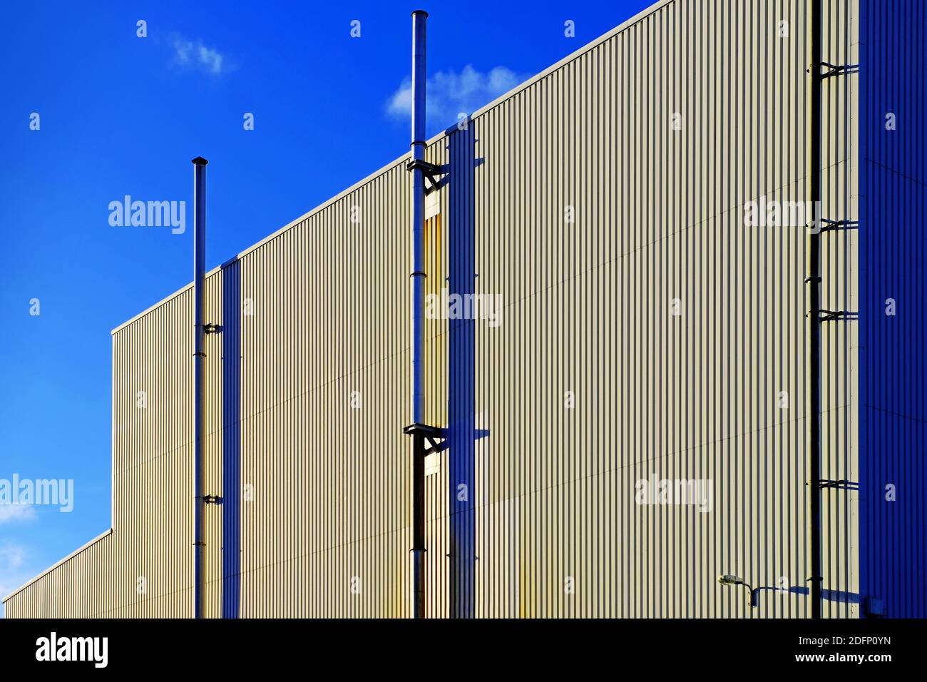 Murs d'usine à corrènement vertical de gauche à droite en diagonale avec ventilateurs et ciel bleu profond Banque D'Images