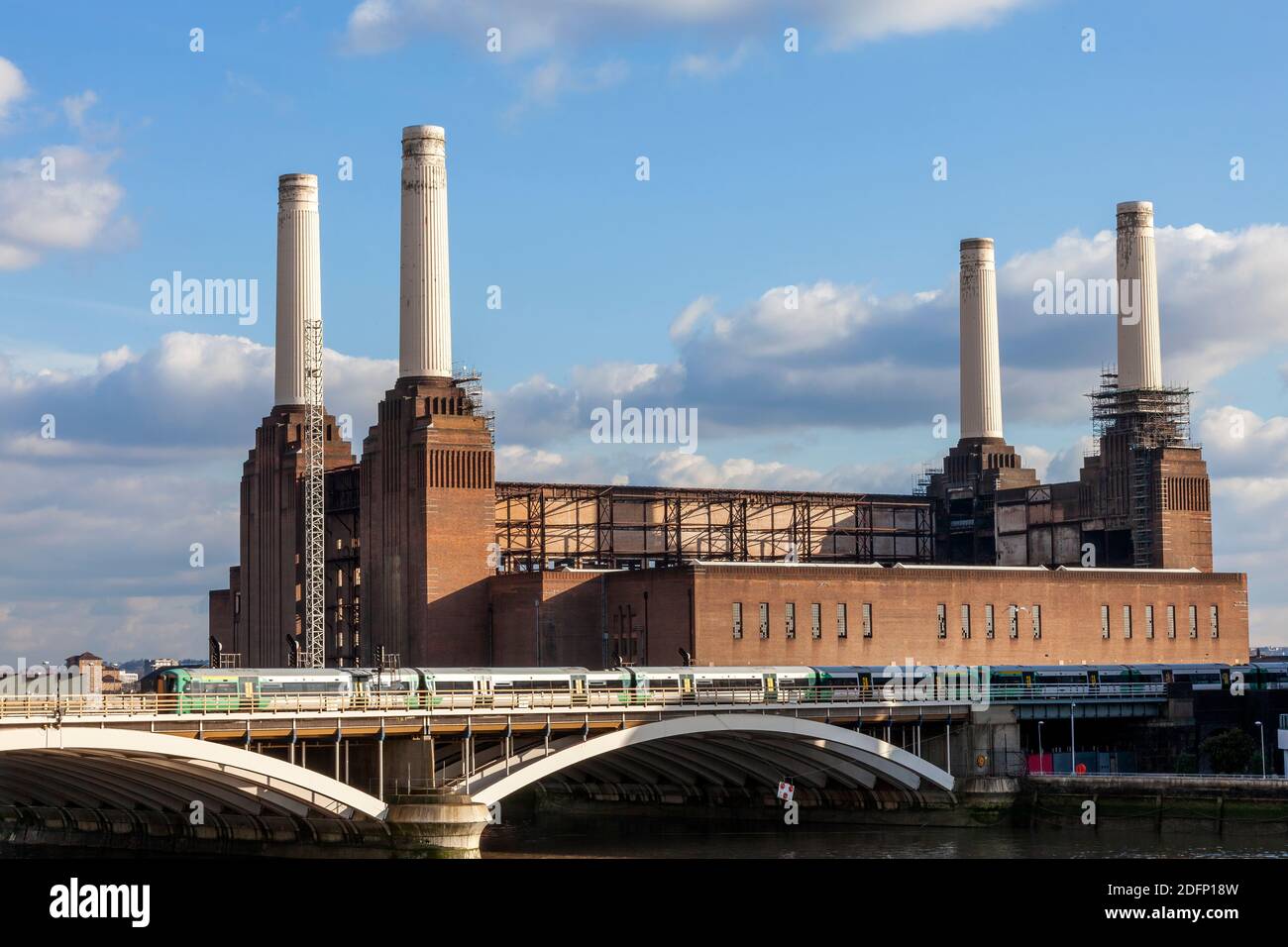 Battersea Power Station à Londres Angleterre Royaume-Uni un charbon a tiré Bâtiment construit en 1935 sur la Tamise avec un passage d'un train de chemin de fer montrant une boîte de vitesses publique Banque D'Images