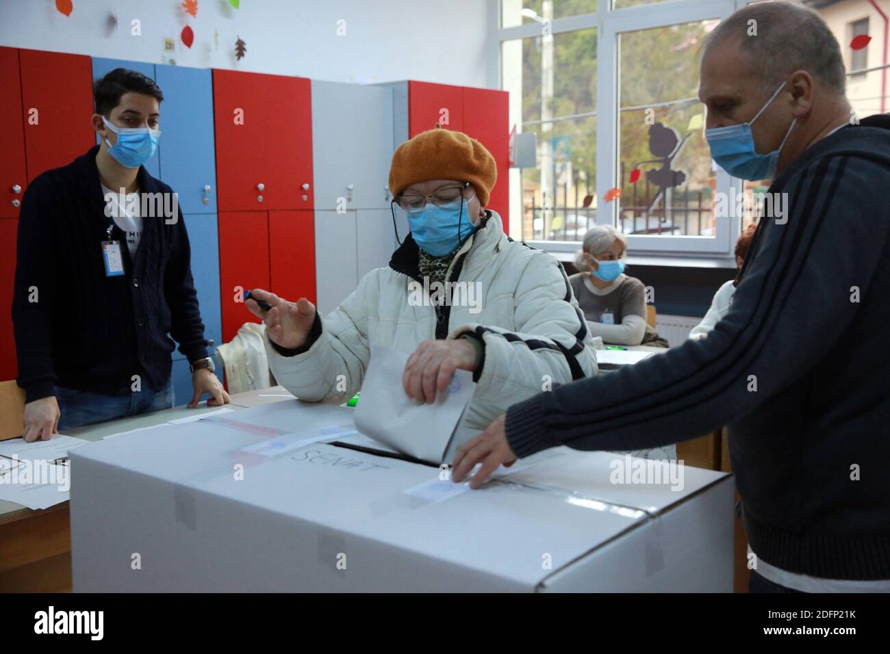 Bucarest, Roumanie. 6 décembre 2020. Une femme portant un masque projette son bulletin de vote dans un bureau de vote à Bucarest, en Roumanie, le 6 décembre 2020. Dans le cadre de mesures de protection spéciales, plus de 18 millions de Roumains devraient voter dimanche pour élire un nouveau Parlement bicaméral pour les quatre prochaines années. Credit: Gabriel Petrescu/Xinhua/Alay Live News Banque D'Images