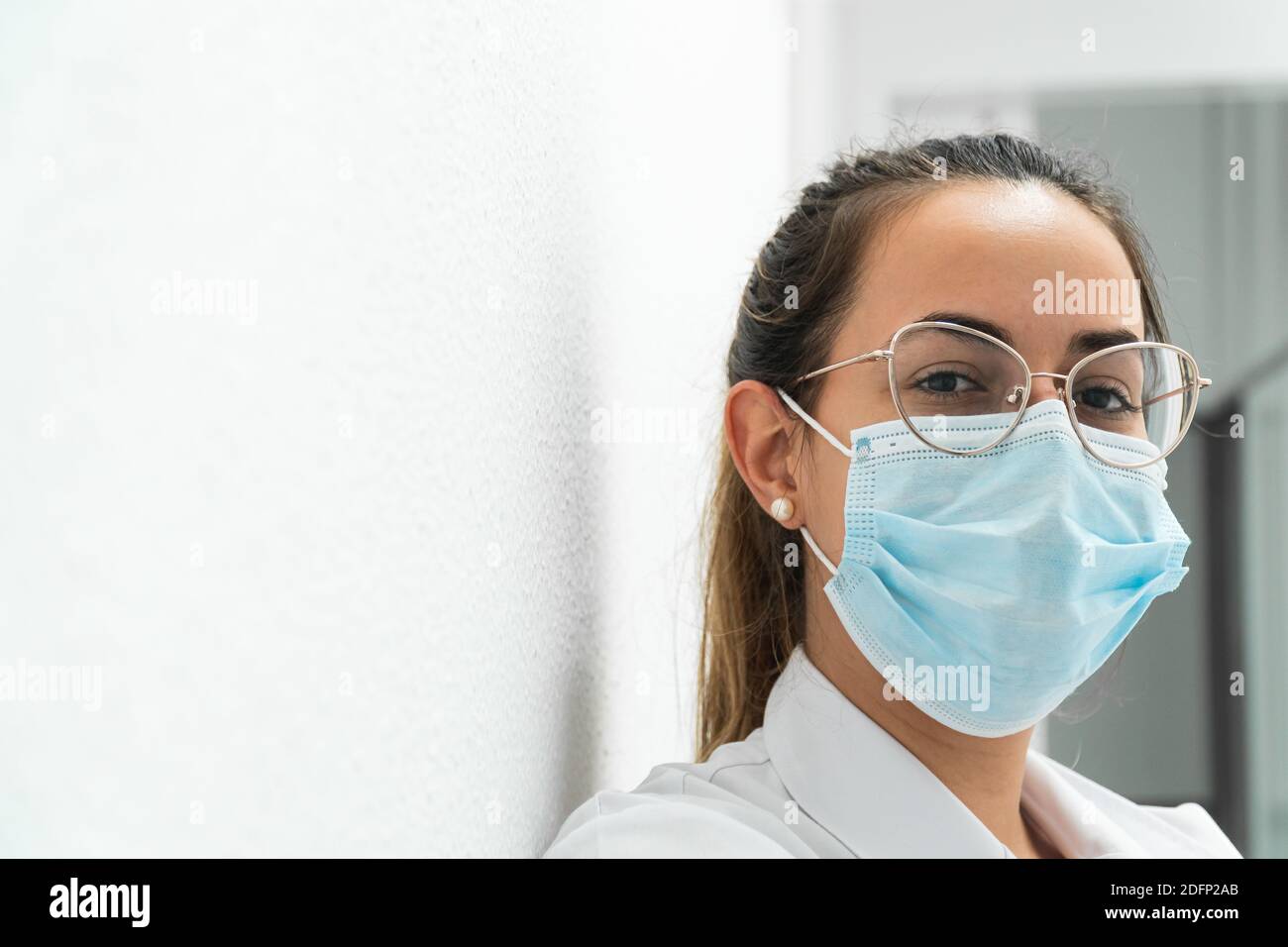 Portrait d'un jeune médecin portant un masque sur un arrière-plan blanc Banque D'Images