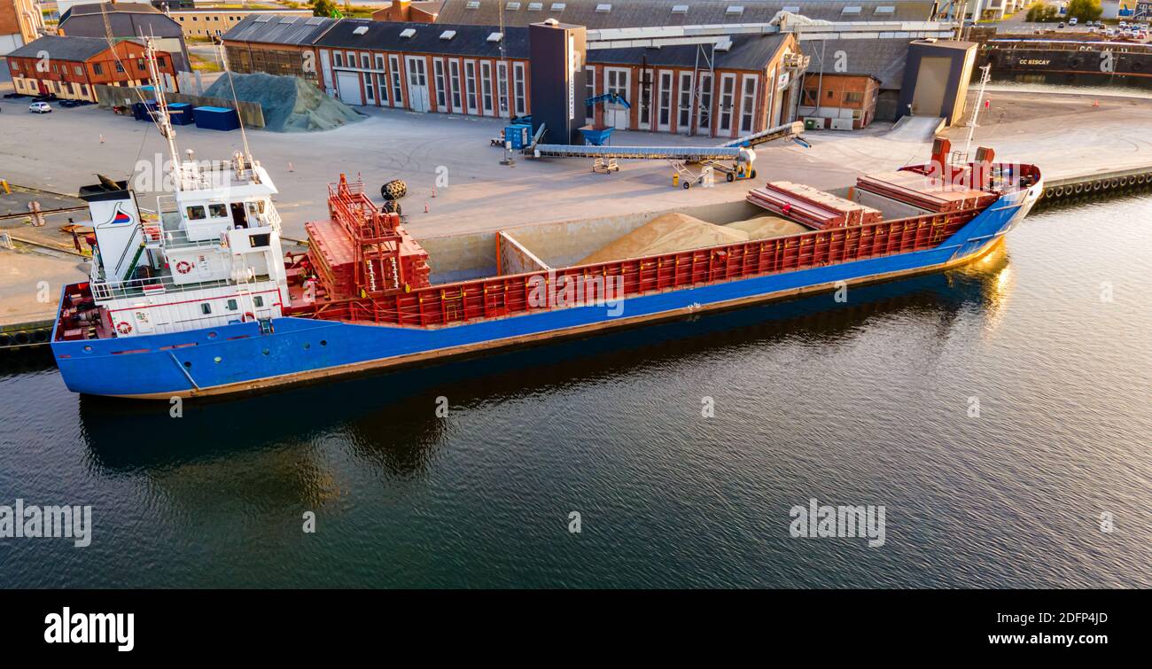 Cargo chargeant du grain dans ses coques ouvertes dans un port. Banque D'Images