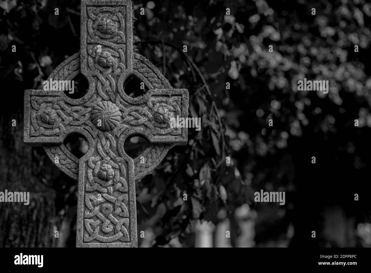 Croix celtique ornée en noir et blanc. Scène sombre. Banque D'Images