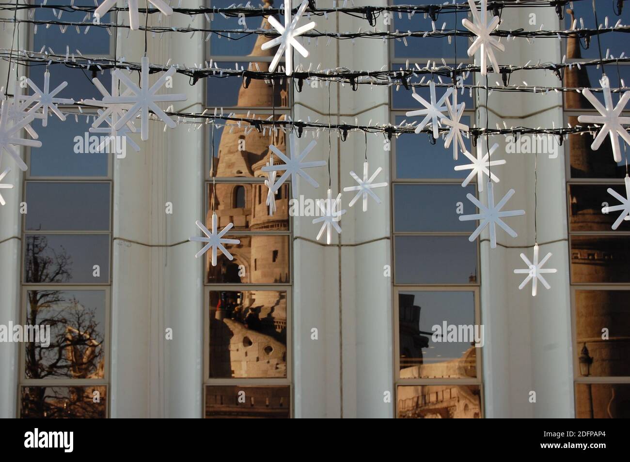 décorations en forme de flocons de neige suspendues et le bâtiment du château se reflétant Les fenêtres de Budapest en hiver 2019 Banque D'Images