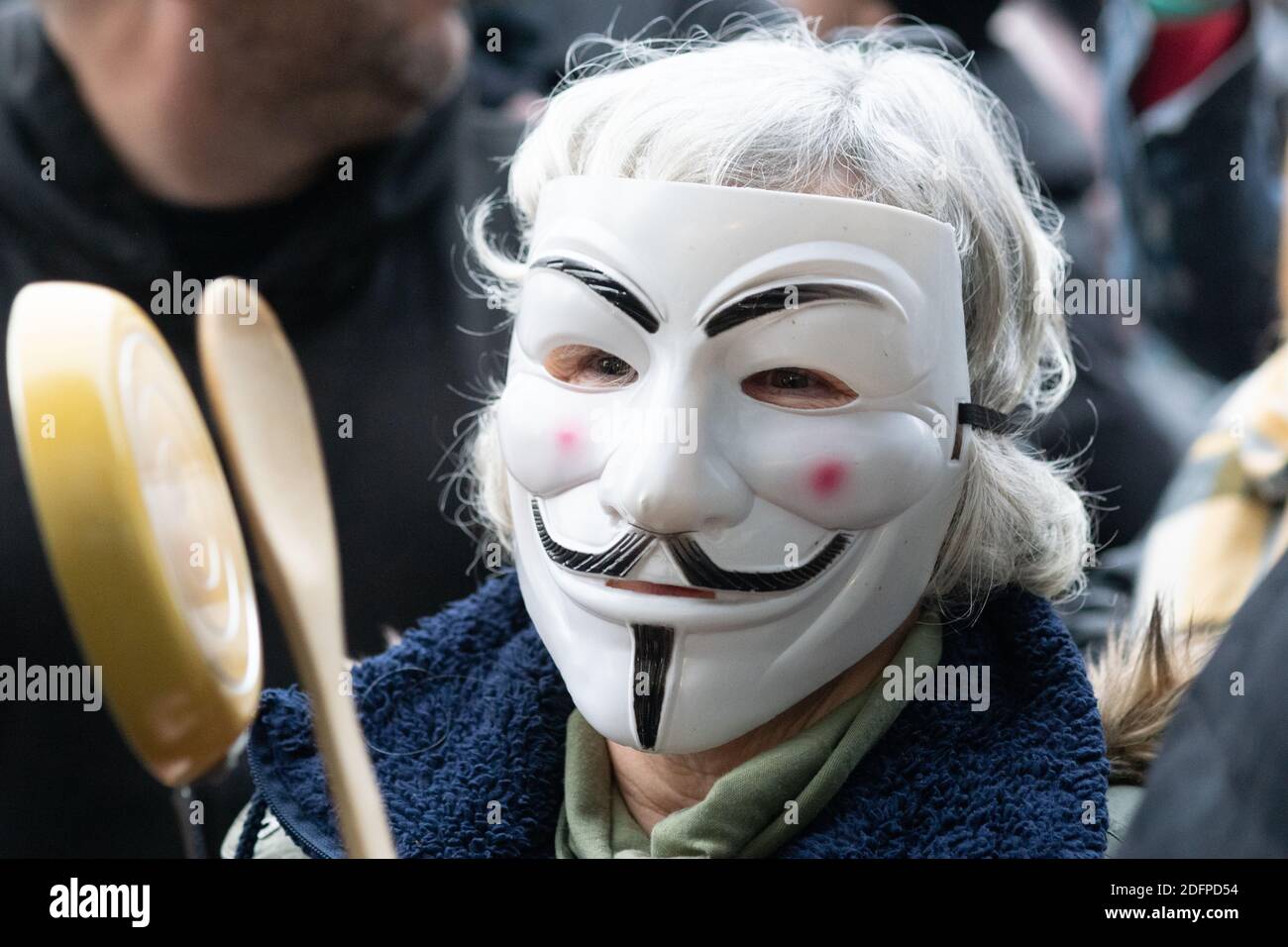Manchester, Angleterre, Royaume-Uni. 6 décembre 2020. Femme âgée portant un masque facial Guy Fawkes ou Anonyme et battant ou frappant un petit pot avec une cuillère en bois à un rassemblement anti-verrouillage dans les jardins de Piccadilly. Crédit : Callum Fraser/Alay Live News Banque D'Images
