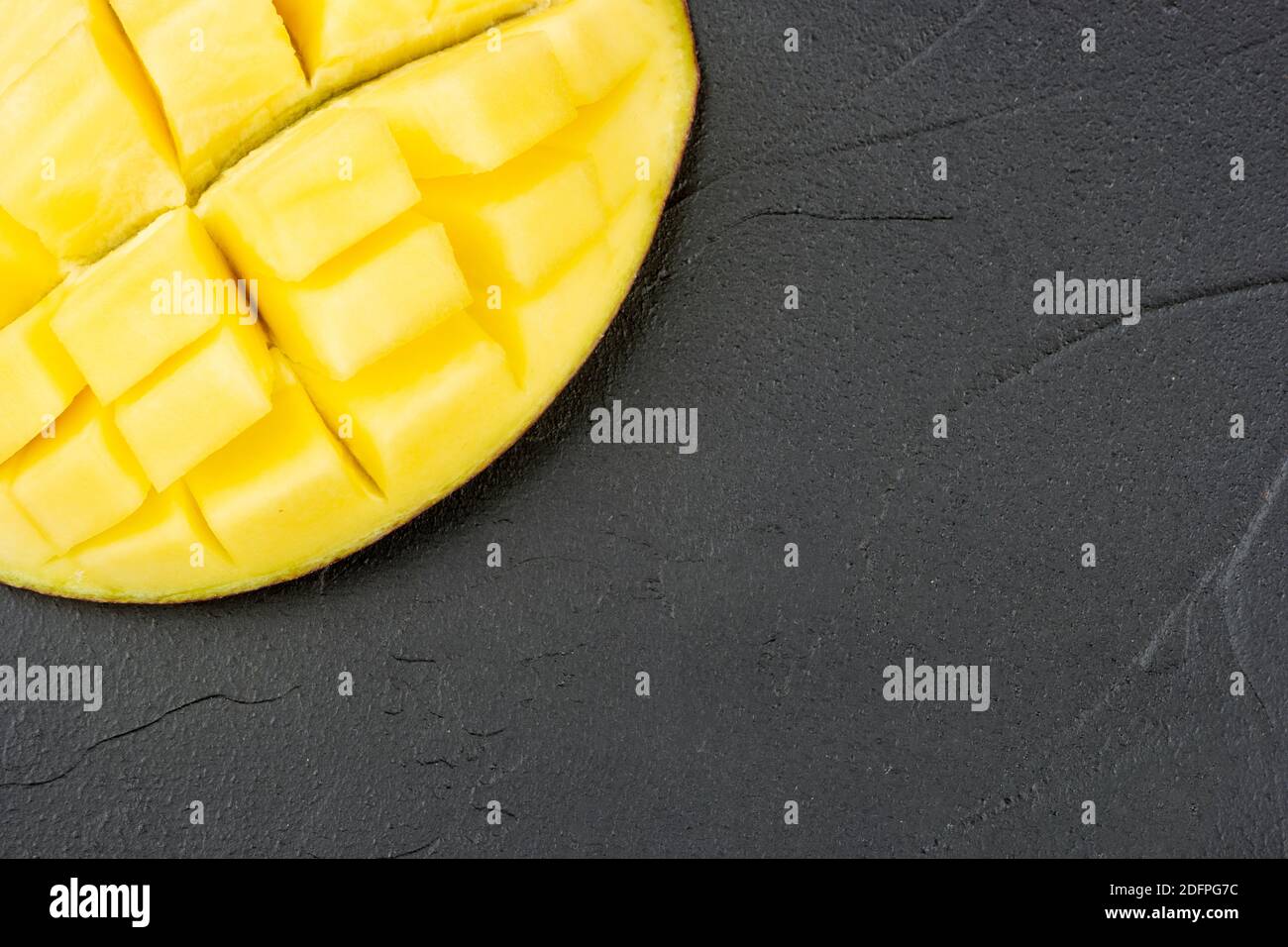 Partie d'une moitié de mangue en tranches sur une sombre vide arrière-plan Banque D'Images