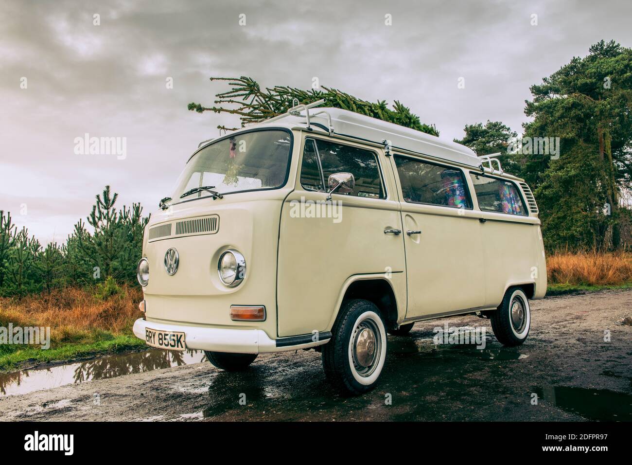 Camping-car vintage avec arbre de Noël fraîchement coupé sur le toit. Banque D'Images