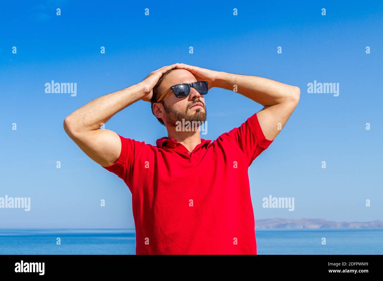 Jeune homme expressif dynamique ambitieux réussi barbu en t-shirt rouge  lunettes de soleil en été bleu ciel océan fond. Concept de liberté de style  de vie Photo Stock - Alamy