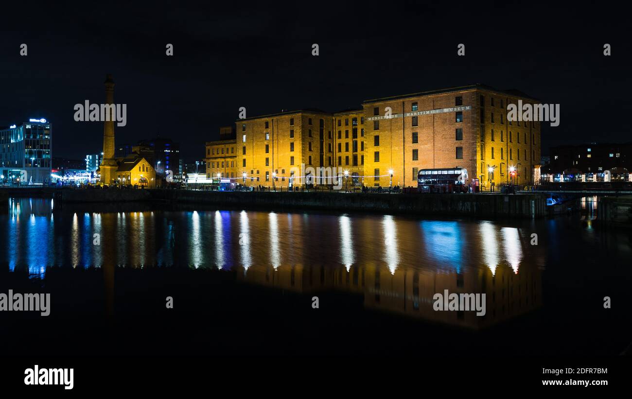 Le Musée maritime de Merseyside se reflète dans l'eau de Canning Dock, Liverpool une nuit en décembre 2020. Banque D'Images