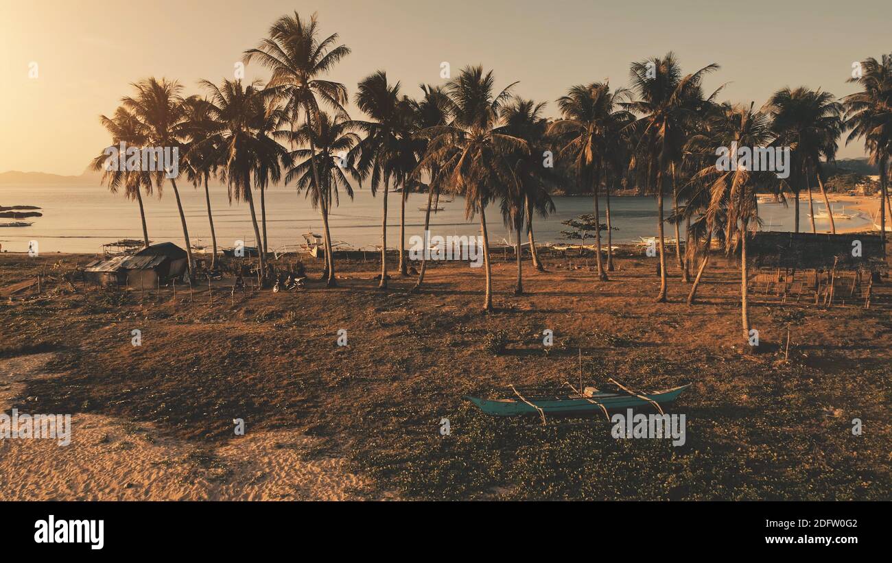 Sun Paradise Island. Bateau traditionnel au bord de la mer. Les touristes aux palmiers. Plage de sable sur la côte de l'océan avec des navires, des navires. Paysage tropical de la nature à l'île El Nido, Palawan, Philippines, Asie Banque D'Images