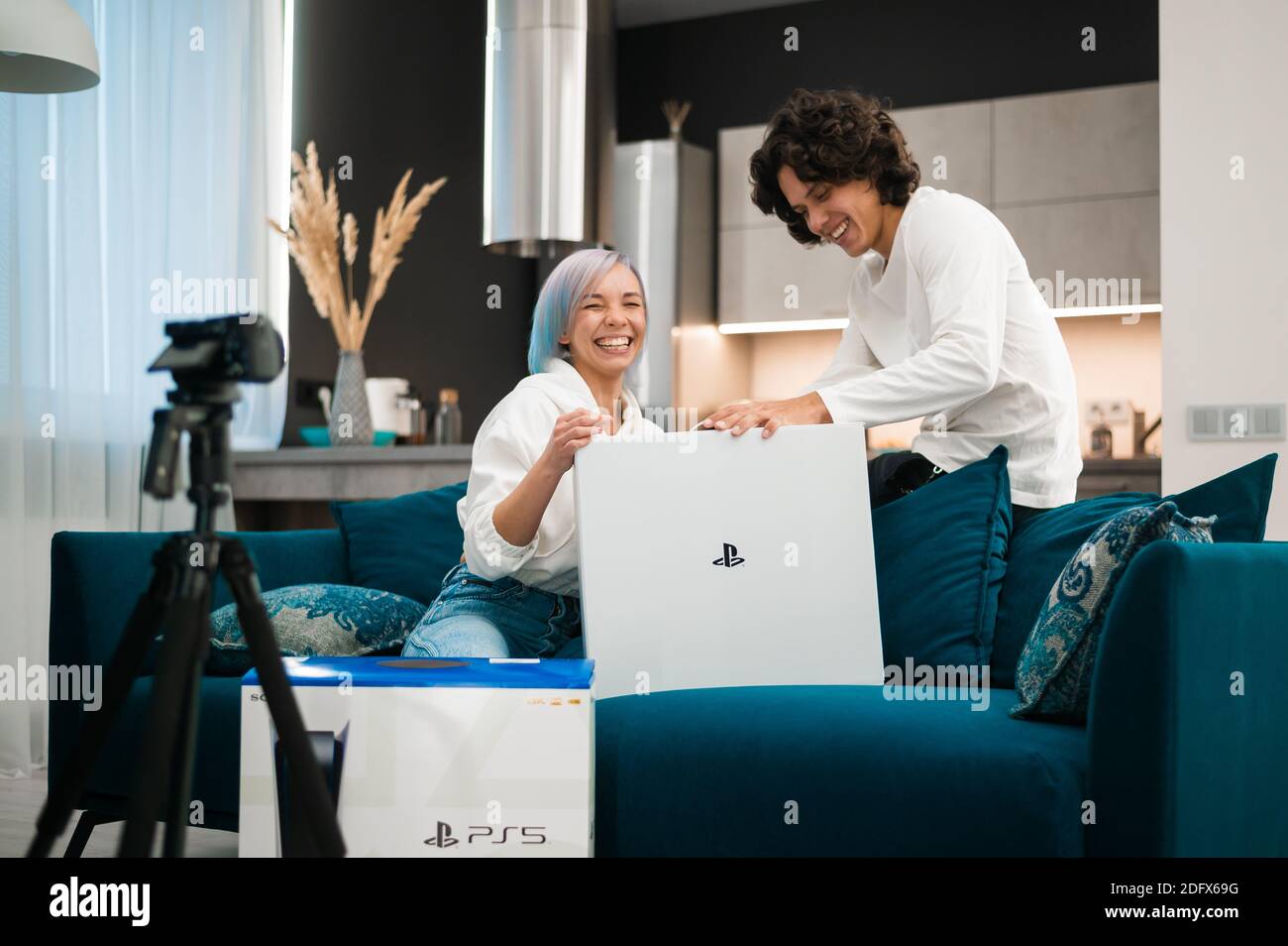Un jeune couple heureux qui débarque la toute nouvelle console de jeu Sony PlayStation 5 chez lui. Moscou - novembre 28 2020. Banque D'Images
