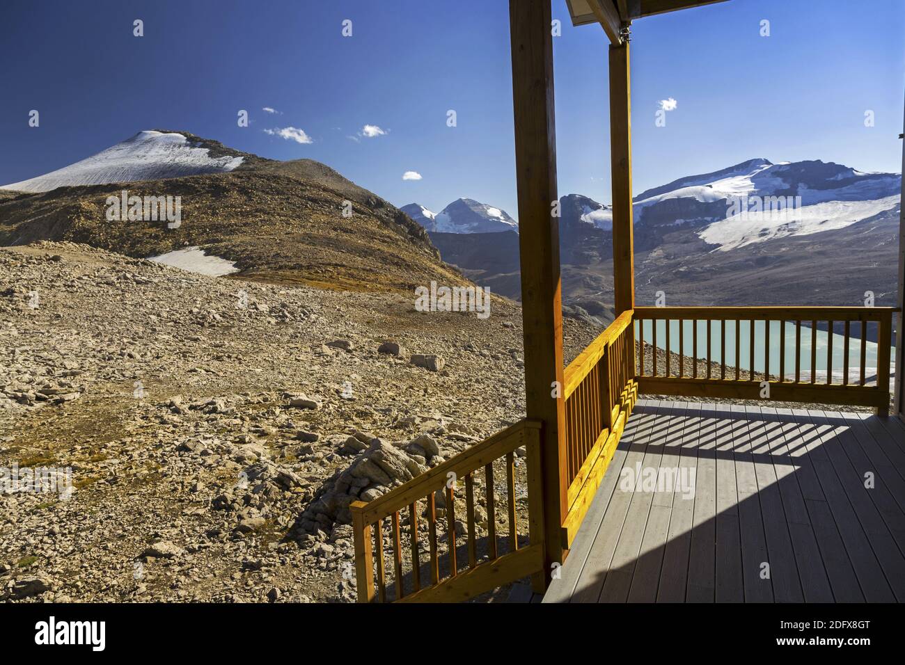 Véranda ensoleillée ou Verandah of Alpine Club of Canada Guy Hutte avec les sommets éloignés de montagne du parc national Yoho sur Horizon Banque D'Images