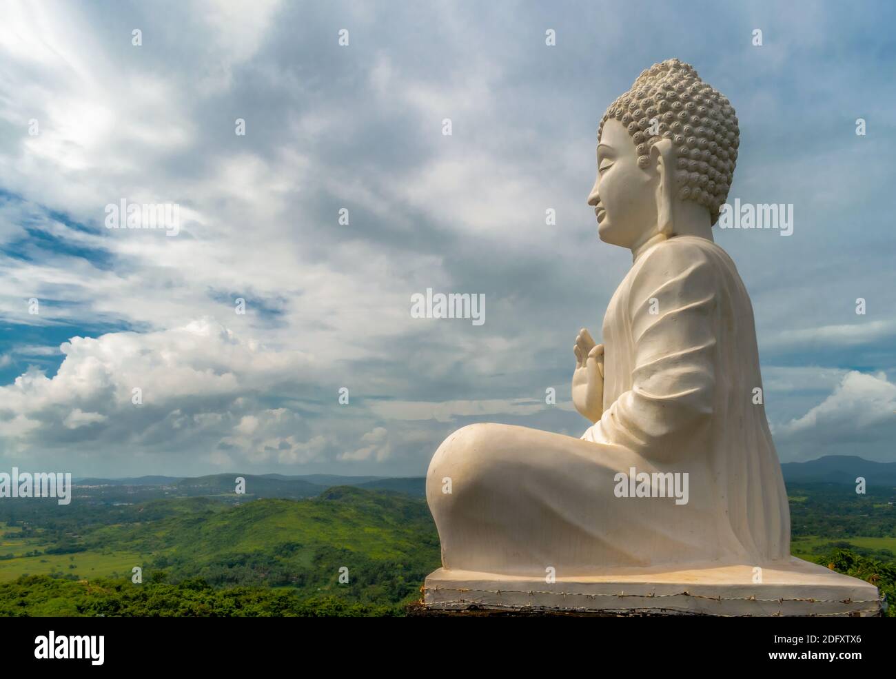 Photo étonnante de la statue de Bouddha de Seigneur en blanc, assis dans la posture de méditation tout en donnant des sermons au sommet de la colline d'où toute la vallée a pu être vue. Banque D'Images