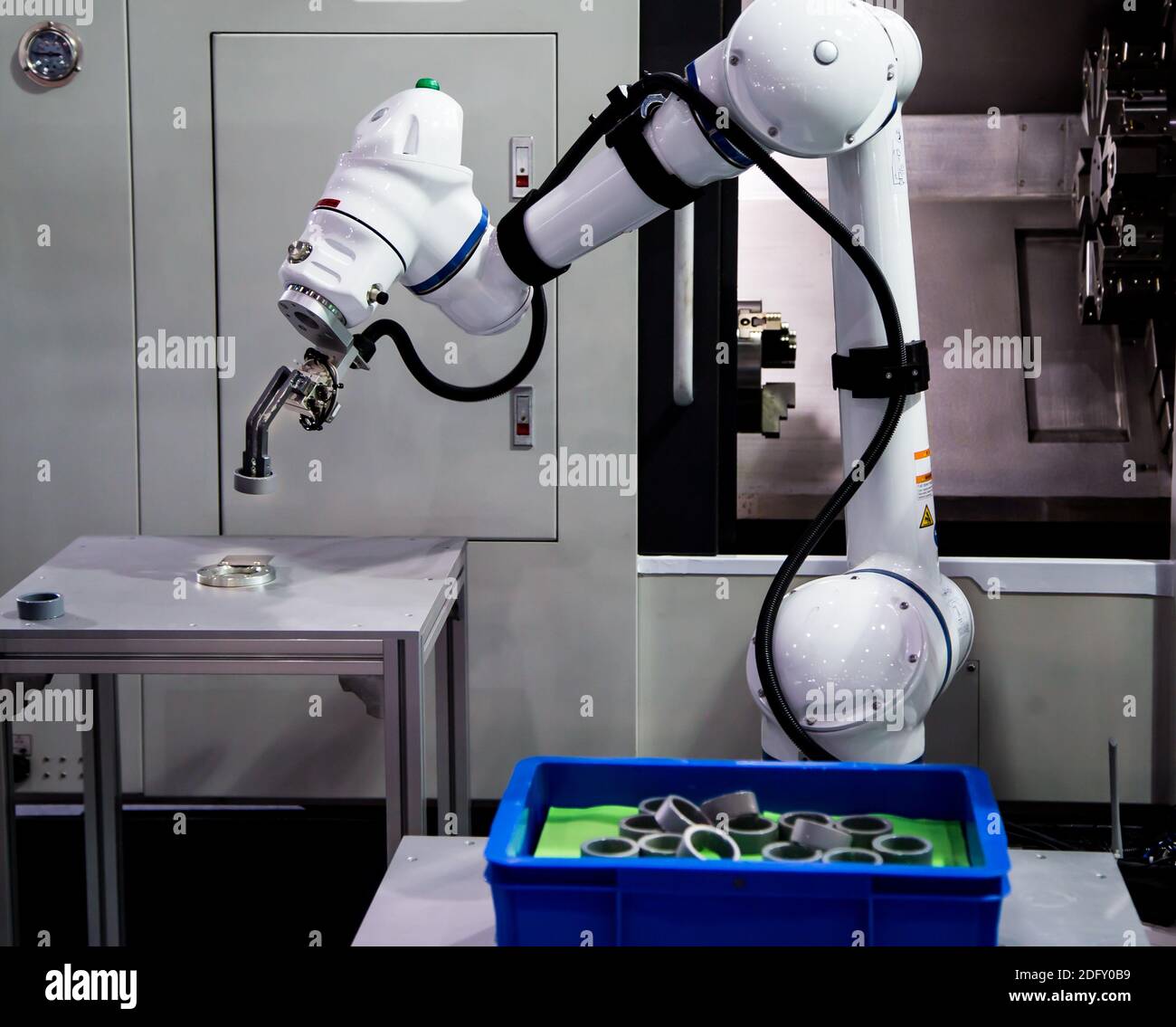 Robot industriel à processus automatisé chargeant la pièce métallique sur la machine CNC. Fabrication industrielle Banque D'Images