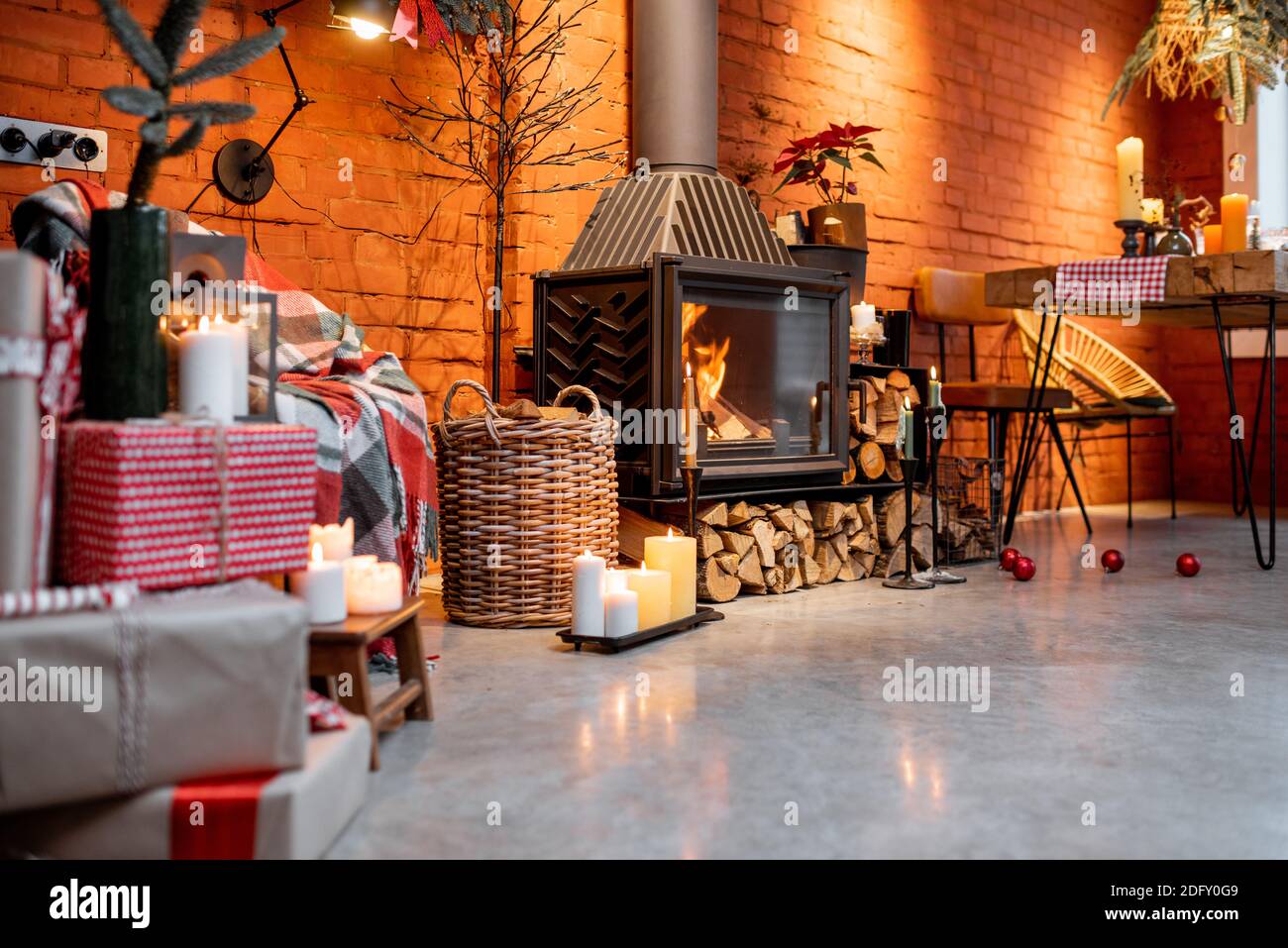 Coin cheminée d'un bel intérieur de style loft avec de véritables planchers de briques et de béton décorés pour les vacances du nouvel an. Le concept de confort à la maison Banque D'Images