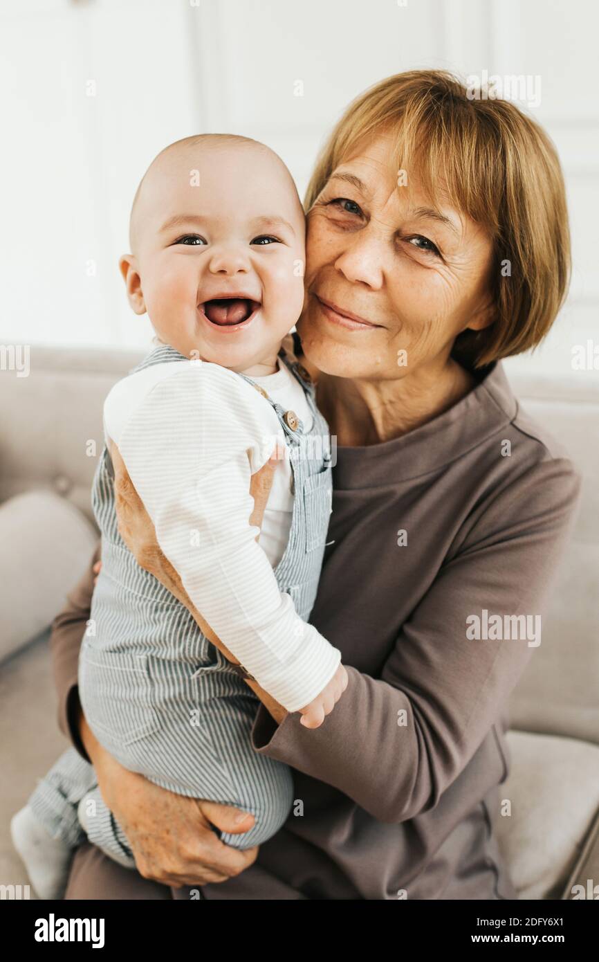 Portrait D Une Grand Mere Et De Son Petit Fils De 8 Mois Dans Un Bel Interieur Lumineux Une Femme Tient Un Bebe Garcon Dans Ses Bras Concept De Famille Photo Stock Alamy