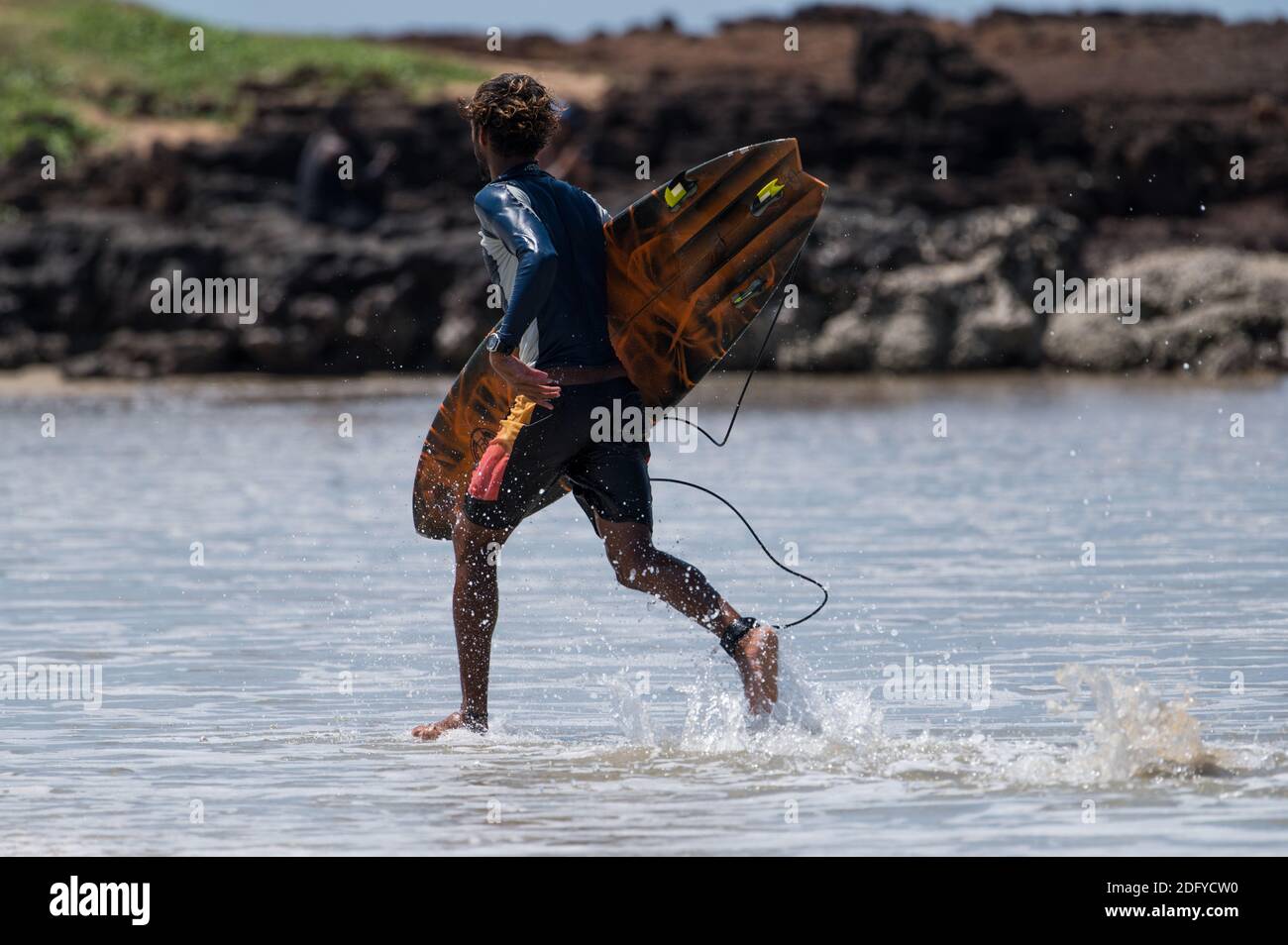 VARKALA, INDE - 14 mars 2020 : un surfeur masculin indien qui se dirige vers le SH Banque D'Images