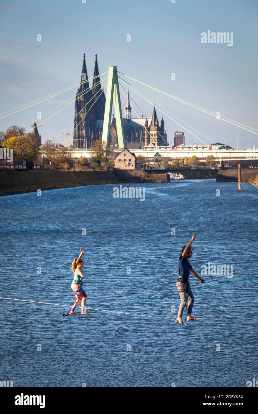 Homme et femme sur les lignes de relâchement dans le port du Rhin dans le quartier Deutz, en arrière-plan la cathédrale et le pont Severins, Cologne, Allemagne. Banque D'Images