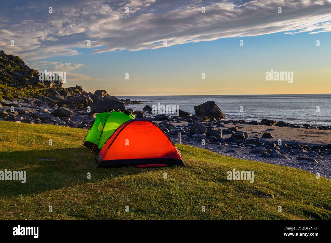 Camping au coucher du soleil avec tentes sur la plage d'Uttakleiv dans les îles Lofoten, Norvège Banque D'Images