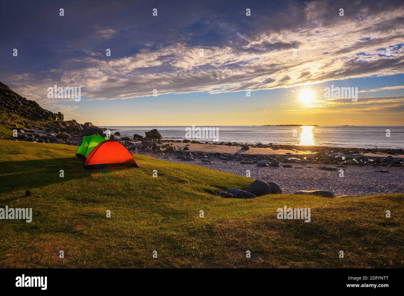 Camping au coucher du soleil avec tentes sur la plage d'Uttakleiv dans les îles Lofoten, Norvège Banque D'Images