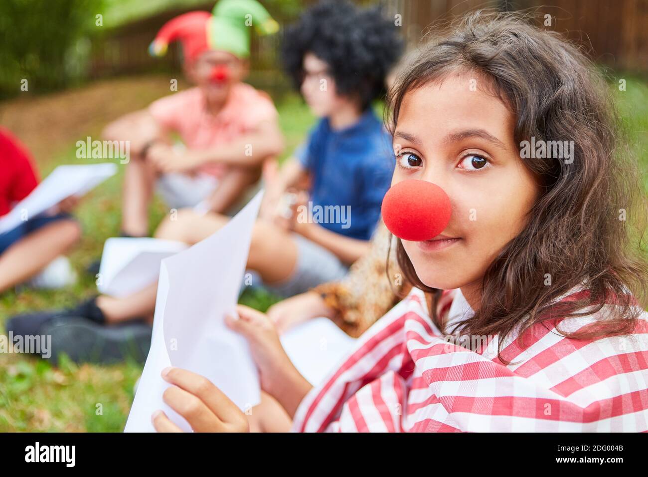 Fille au nez clown s'exerçant pour la performance sur le spectacle de talent au camp d'été Banque D'Images