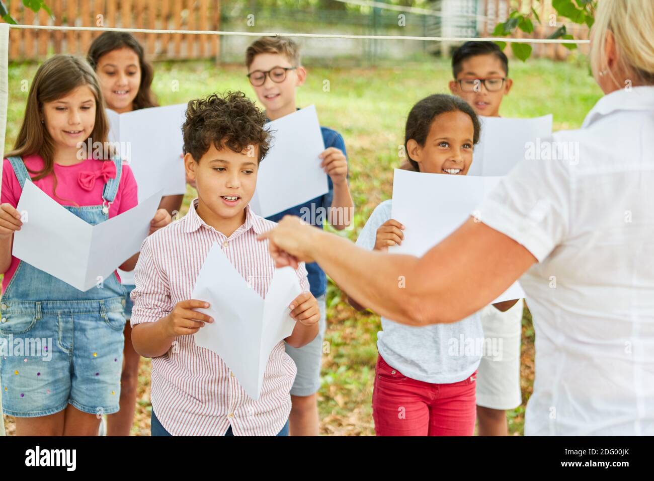 Groupe d'enfants comme chœur d'enfants dans un chœur répétition du spectacle de talents dans le camp de vacances Banque D'Images