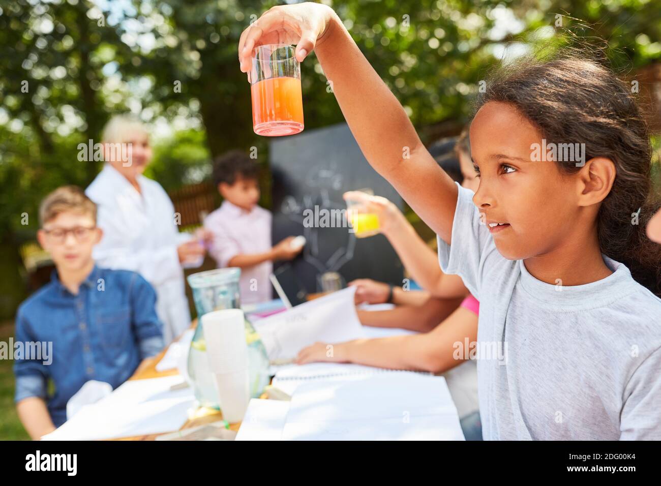 Fille tient le verre à l'expérience dans le camp d'été de chimie tutorat cours Banque D'Images