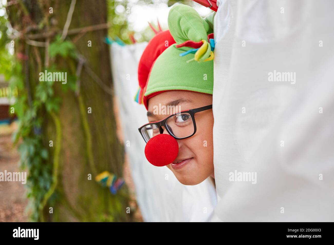 Garçon comme un court jester avec un nez rouge à la représentation théâtrale du spectacle de talents du camp de vacances Banque D'Images