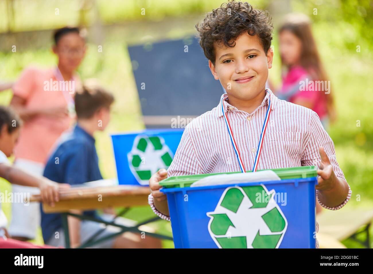 Garçon porte une boîte avec symbole de recyclage comme écologiste bénévole et activiste Banque D'Images