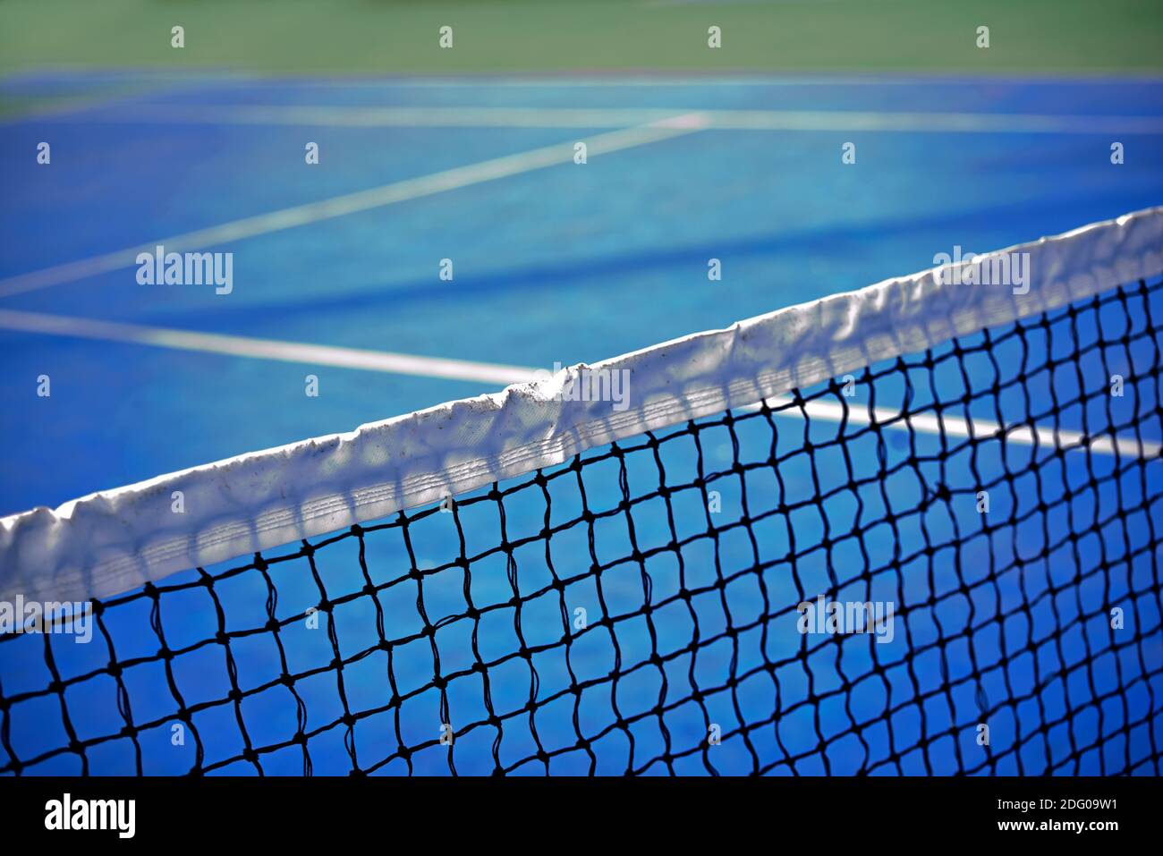 Filet de tennis dans un lieu sportif avec surface de jeu bleue. Une vue sur le net vers la piste opposée. Jeu de tennis. Banque D'Images