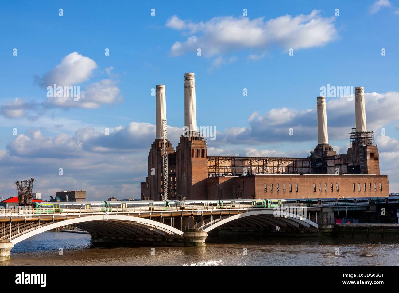 Battersea Power Station à Londres Angleterre Royaume-Uni un charbon a tiré Bâtiment construit en 1935 sur la Tamise avec un passage d'un train de chemin de fer montrant une boîte de vitesses publique Banque D'Images