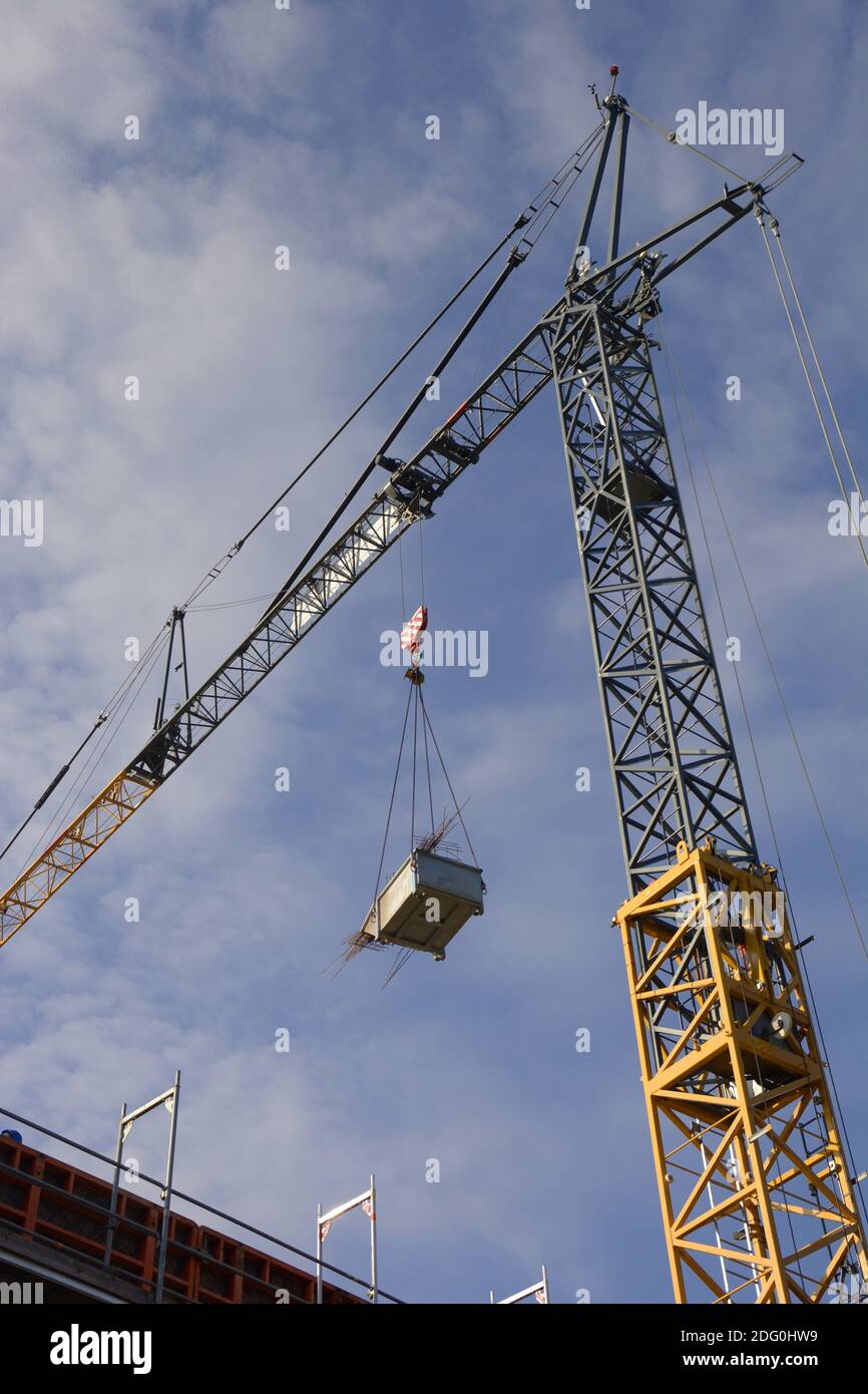 Grue à tour avec chargement sur elle vue de dessous contre le mou ciel nuageux Banque D'Images