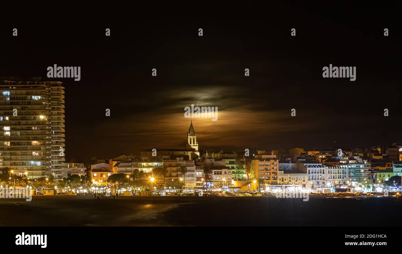 Prise de vue de nuit avec pleine lune derrière les nuages, ville de Palamos en Espagne Costa Brava, Catalogne Banque D'Images
