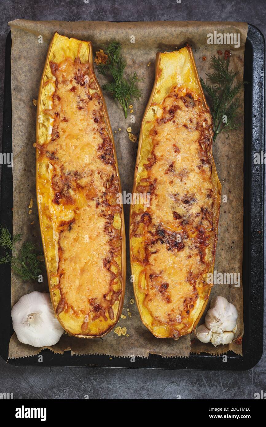 Cuit dans un four courgette jaune avec de la viande, du fromage, de l'ail, des oignons et des tomates sur une plaque de cuisson. Banque D'Images