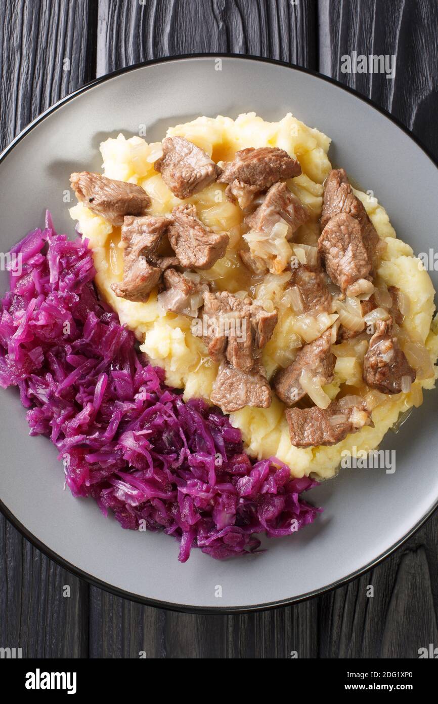 Ragoût de bœuf et d'oignon Hachee servi avec une purée de pommes de terre, un chou rouge braisé dans l'assiette sur la table. Vue verticale du dessus Banque D'Images