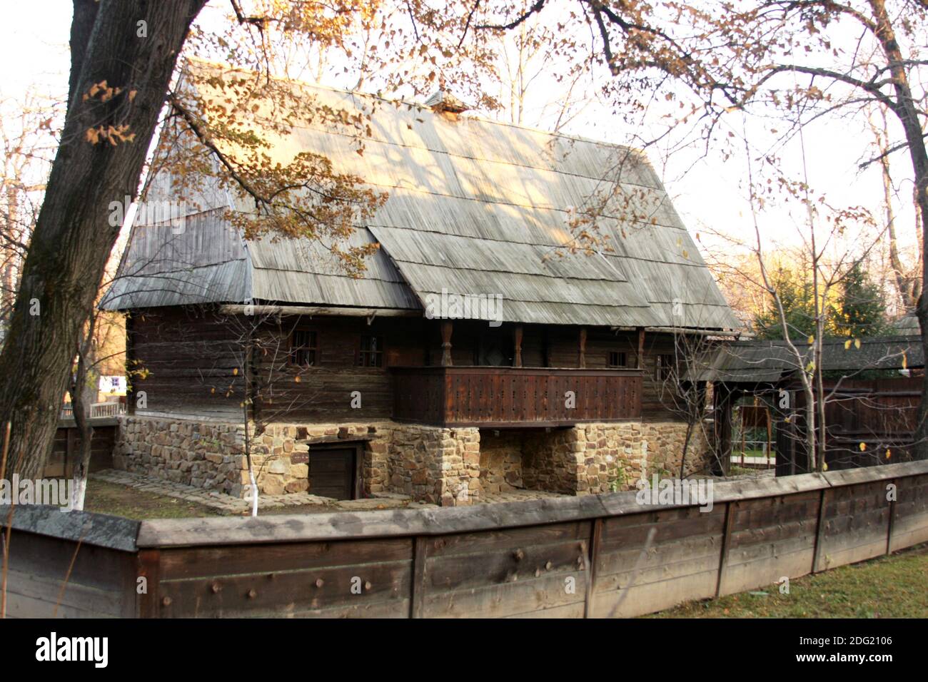 Musée du village, Bucarest, Roumanie. Maison en bois du XIXe siècle du comté de Sibiu, avec toit en ardoise en bois, balcon, fondation en pierre et cave. Banque D'Images