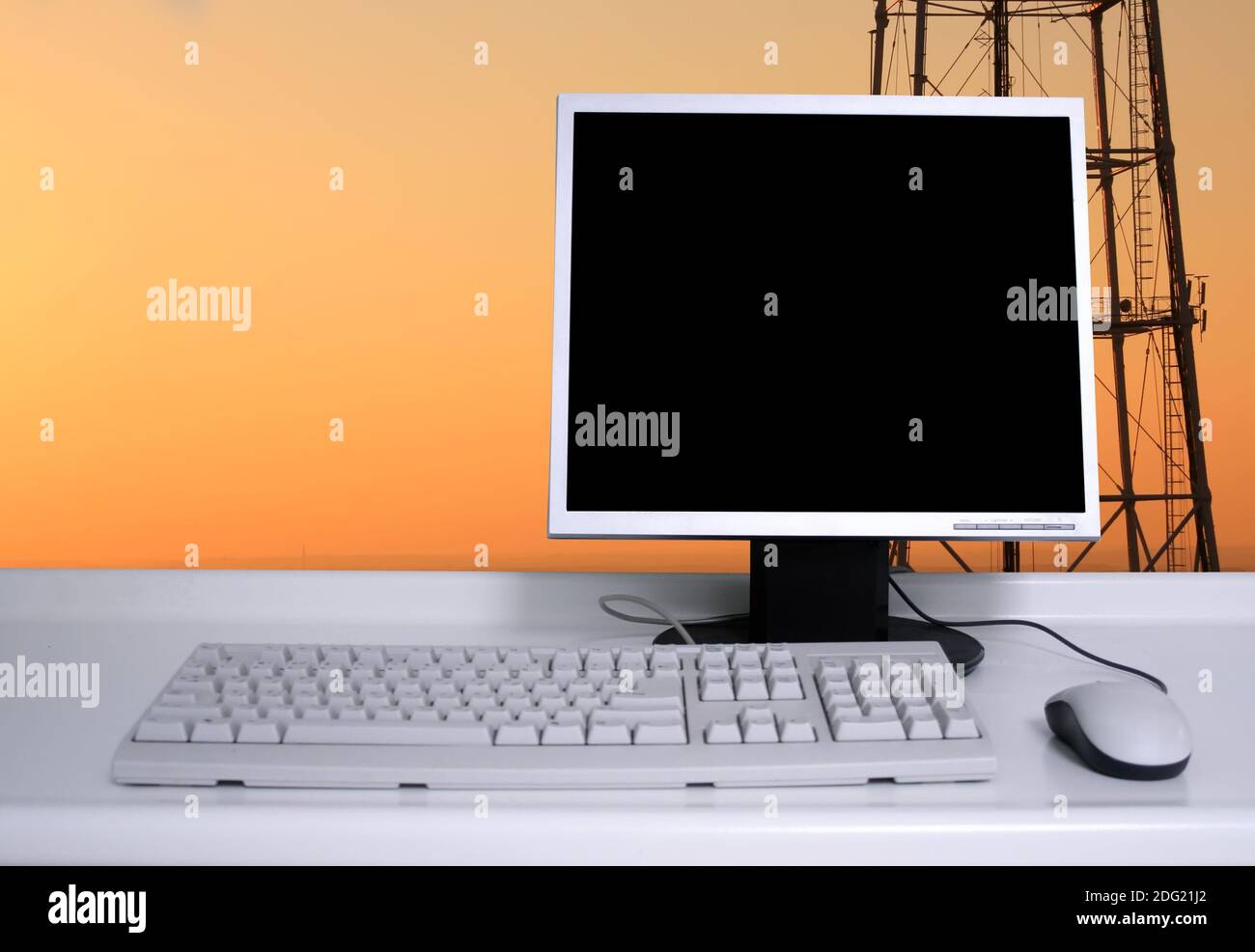 PC avec ciel de coucher de soleil et fond de pylônes électriques Banque D'Images