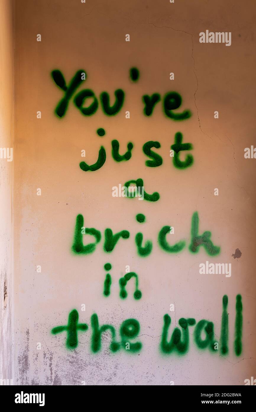 Mur de maison démoli avec l'inscription effrayante « You're just a brick in the Wall » dans le village fantôme d'Al Madame, Émirats arabes Unis. Banque D'Images