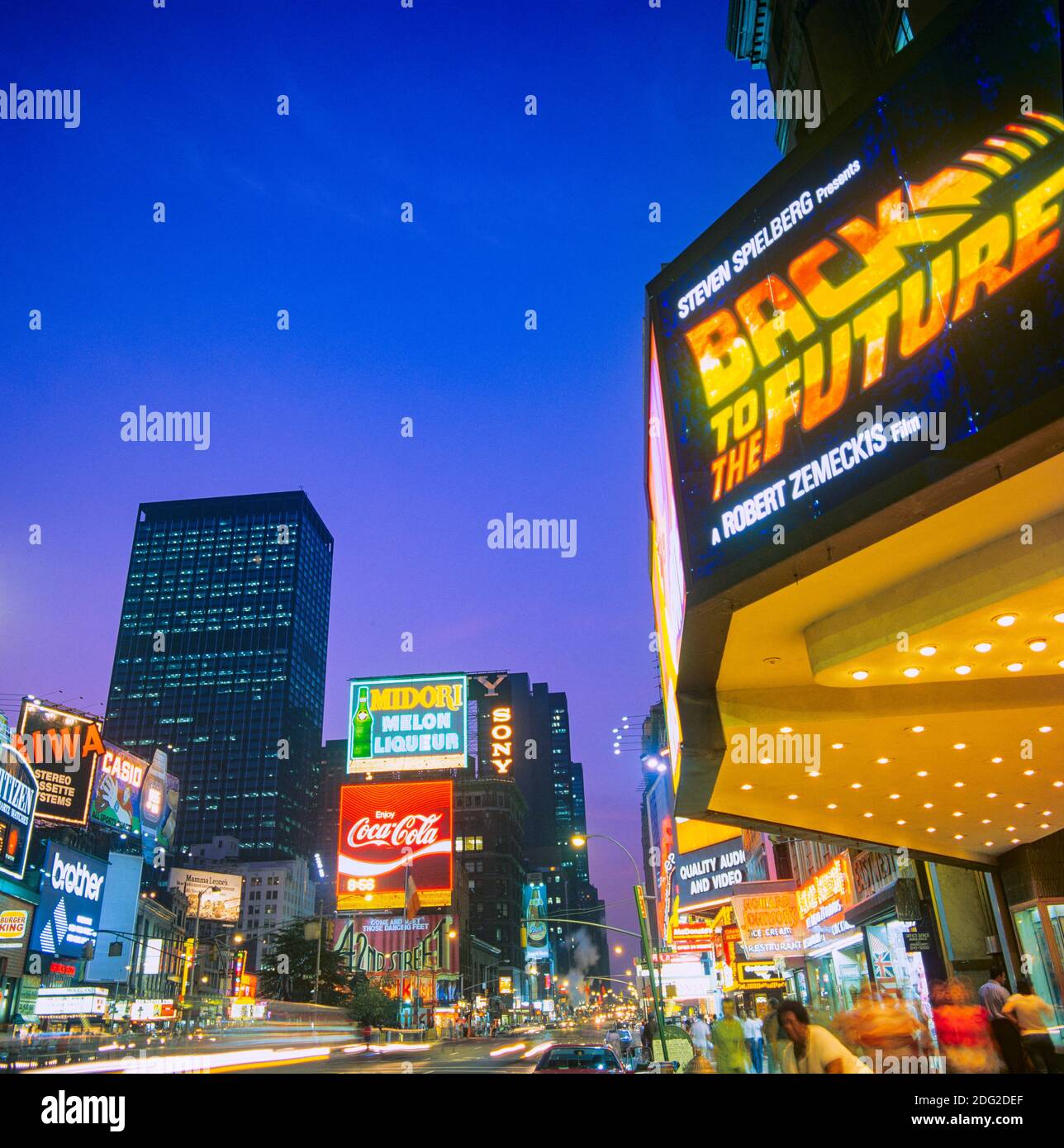 New York 1985, Times Square au crépuscule, panneaux publicitaires lumineux, marquise de cinéma, publicité de cinéma « retour au futur », People, Midtown Manhattan, New York City, NY,NYC, ETATS-UNIS, Banque D'Images