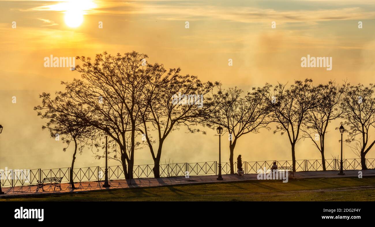 Silhouettes de personnes marchant le long du Paseo de las Murallas De Baeza (Espagne) un après-midi d'hiver avec un spécial léger Banque D'Images